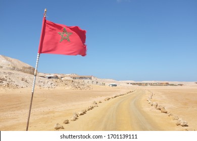 Desert Road with Moroccan Flag in Western Sahara Leading to Tourist Resort