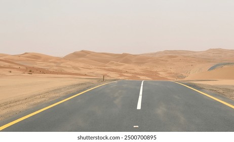 Desert road with sand blown onto asphalt, basking in bright sunlight. Scene captures rugged beauty of desert and relentless encroachment of sand on path Concept Desert Adventure Road Trip - Powered by Shutterstock