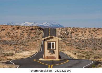 Desert Road Security Booth in Utah, with snow capped mountains  - Powered by Shutterstock