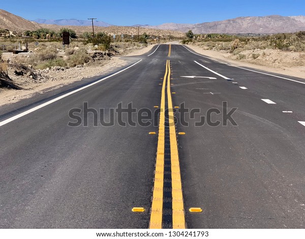 Desert road without people\
and cars.