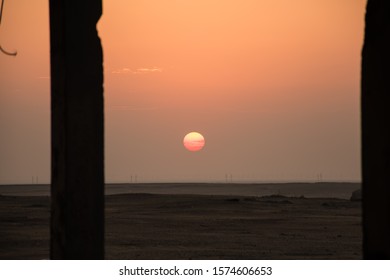 Desert Sun Rise Is The Main Object Focus Through The Pillars In Beautiful  Morning At Abdali, Kuwait.