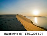 Desert at sunrise, morning glow over dunes and inland sea of the Sealine Desert just out of Doha, Qatar.