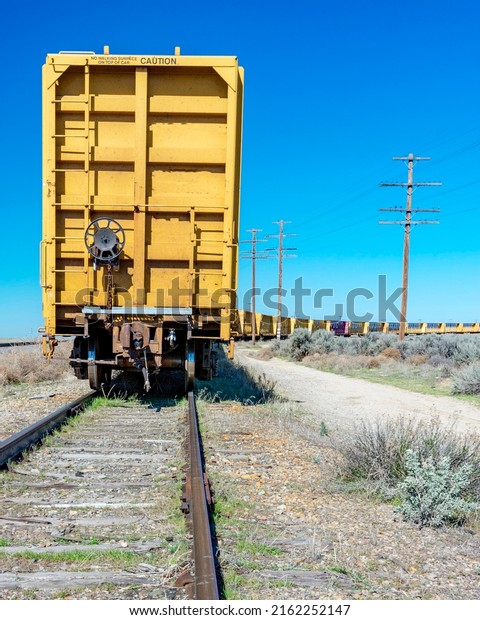 Desert train tracs\
with yellow cars on them\
