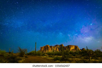 The Desert Wilderness Of America's Southwest Grows Dark At Night As The Sky Lights Up With Brightly Twinkling Stars And The Milky Way Shoots Across The Sky Over Iconic Superstition Mountains And Cacti