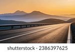 Deserted asphalt road and mountain landscape at dawn