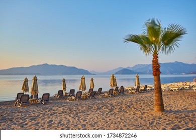 Deserted Beach In The Morning Sun. The Beach At Dawn. Empty Sunbeds. Beach Without People. Marmaris, Turkey.