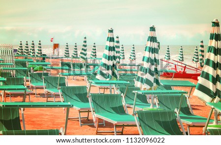 Deserted beach with sunbeds and umbrellas at the Italian Adriatic coast near Rimini and Riccione in the preseason, Italy
