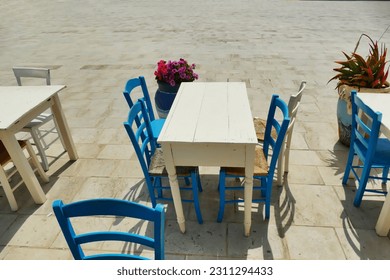 Deserted grunge style wooden table and chairs on sidewalk - Shutterstock ID 2311294433