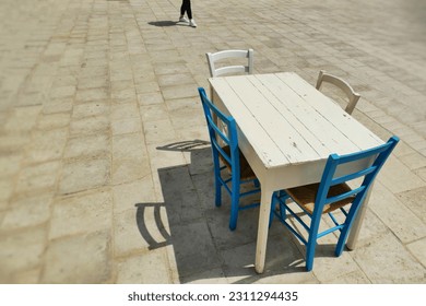 Deserted grunge style wooden table and chairs on sidewalk - Shutterstock ID 2311294435
