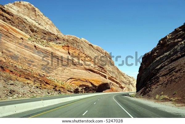 Deserted\
highway in San Rafael Reef mountains,\
Utah