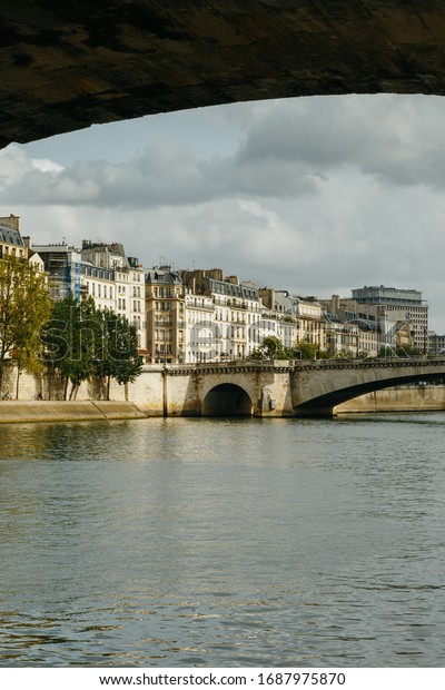 Deserted old Paris streets with no tourists and no\
cars while citizens stay at home in self isolation. Seine river\
with no ships. Residential buildings facades, typical architecture,\
economy crisis