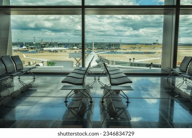 deserted waiting room at the airport with a view of the area with the planes outside the window.