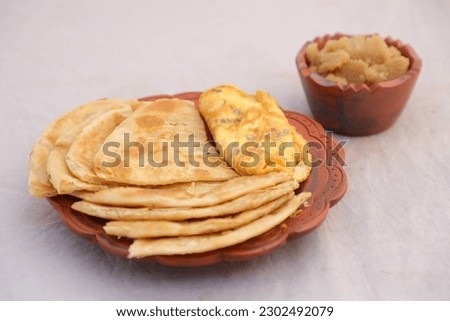 Desi breakfast omelet, halwa and paratha served in dish isolated on background top view of bangladesi breakfast