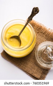 Desi Ghee or clarified butter in glass or Copper container or ceramic jar with spoon, selective focus
