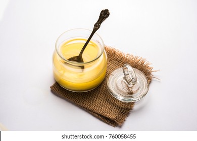 Desi Pure Ghee or clarified butter in glass or Copper container with spoon, selective focus
