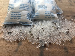 Desiccant Silica Gel On Wood, Used For Moisture Protection In The Food Industry, On Packaging Has The Label Clearly Labeled "Desiccant, Silica Gel, Throw Away, Do Not Eat"