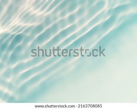 Closeup​ abstract​ of​ surface​ blue​ water​ for​ graphic​ design. Reflection​ of​ sunlight​ to​ surface​ blue​ water​ for​ background. Blue​ water​ splash​ed​ for​ background. Blue​ water​ texture.