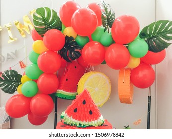 Design of balloons. Many red and green balloons decorated wall. Bright and juicy design in tropical style. Children party. Fruit tropical candy bar