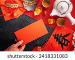 Design concept of Chinese lunar January new year - Woman holding, giving red envelopes (ang pow, hong bao) for lucky money, top view, flat lay, overhead above. The word 