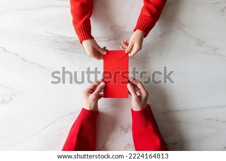 Design concept of Chinese lunar January new year 2023. Woman holding hands and giving to kid red envelope for lucky money