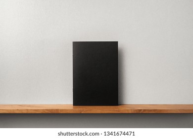 Design Concept - Front View Of Black Magazine Stand On Bookshelf And Grey Wall For Mockup, Not 3D Render