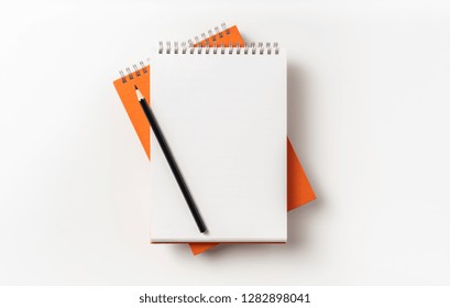 Design Concept - Top View Of 2 Orange Spiral Notebook, White Page And Pencil Isolated On Background For Mockup