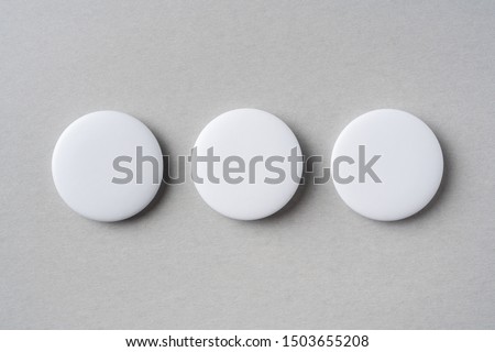 Design concept - top view of 3 white badge on grey background for mockup, it's real photo, not 3D render
