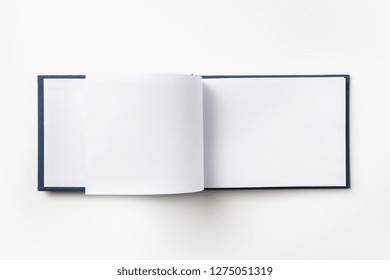 Design Concept - Top View Blue Hardcover Notebook With Open & Flip Curl Rolled Page Isolated On Background For Mockup