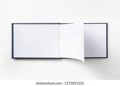 Design Concept - Top View Blue Hardcover Notebook With Open & Flip Curl Rolled Page Isolated On Background For Mockup