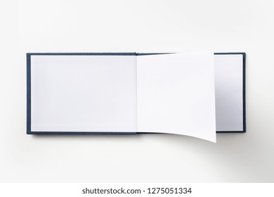 Design Concept - Top View Blue Hardcover Notebook With Open & Flip Curl Rolled Page Isolated On Background For Mockup