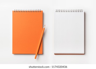 Design Concept - Top View Of Orange Spiral Notebook And Color Pencil Collection Isolated On White Background For Mockup