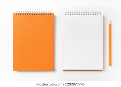 Design Concept - Top View Of Orange Spiral Notebook, White Page And Pencil Isolated On Background For Mockup