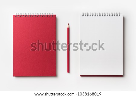 Design concept - Top view of red spiral notebook and color pencil collection isolated on white background for mockup