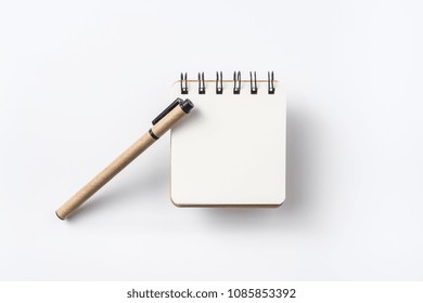 Design Concept - Top View Of Spiral Kraft Notebook And Ballpoint Pen Isolated On White Background For Mockup