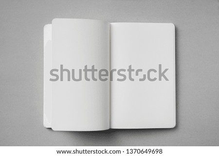 Design concept - top view of white notebook with blank open, turn and flipped page on grey background for mockup. real photo, not 3D render