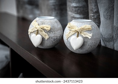 Design Element: Close-Up of Two Small Light-Colored Round Candle Holders Adorned with White Heart Decor. Perfect for enhancing interior decor, adding warmth, and infusing a sense of love and coziness - Powered by Shutterstock