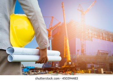 Design Engineer With Hard Hat Holding Drawing Paper In The Construction Project For Planing And Management.