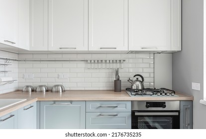 Design Of A Modern Small Light White Kitchen With A Blue Kitchen Cabinets And Loft Lamps