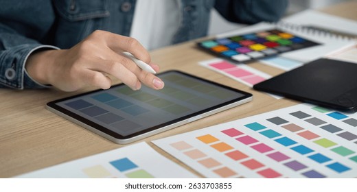 Design Process. Creative designer using tablet for color selection and digital design.