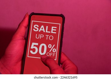 Design sale 50% discount. Hand holding mobile phone with offer message. Special discount promotion red background sale poster template. clipping path - Shutterstock ID 2246321695