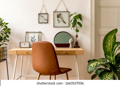 Design scandinavian interior of home office space with a lot of mock up photo frames, wooden desk, a lot of plants, mirror, office and personal accessories. Stylish neutral home staging. Template.