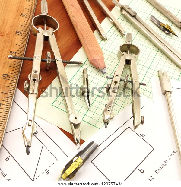 Design Time.  Conglomerate of\
antique drafting tools on engineering paper and wood\
background.