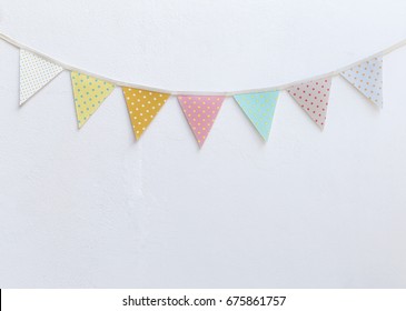 Design Vintage Fabric Party Flag Over White Cement Wall Texture Background, Outdoor Day Light