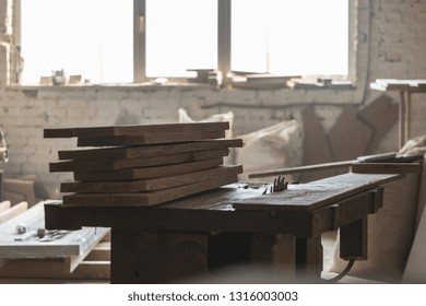 Design Wood Concept. Old Fashioned Rusty Carpenters Tools Lying Under Wooden Tile Boards Composition. Photo Of Wooden Plank Board On Saw Table In Empty Garage Or Workroom Interior