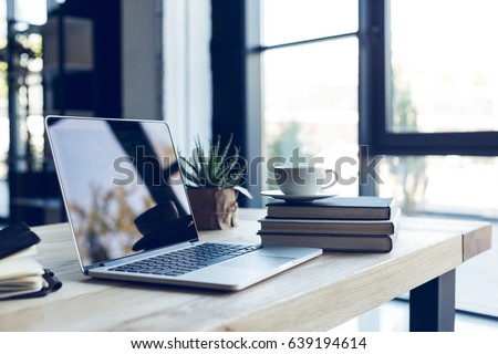 design of workplace with laptop and cup of coffee in home office