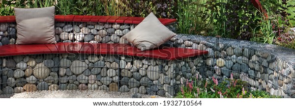Designed\
Backyard Garden Patio and Outdoor Party Place. Modern Garden Design\
and Landscaping. Round Bench Made from Gabions with Wooden Seat.\
Landscaped Family Resting Area with\
Fireplace.