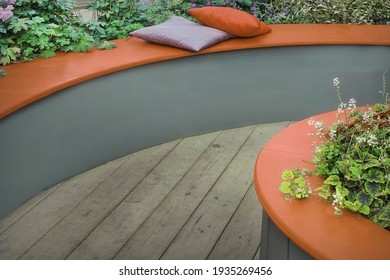 Designed Patio in Backyard Garden and Outdoor Party Place. Modern Garden Design Landscaping. Round Bench Made from Wooden Planks and Soft Leather Couch with Pillow. Landscaped Family Resting Area. - Shutterstock ID 1935269456