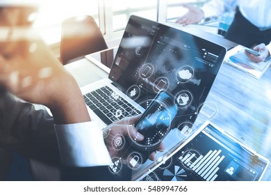 Designer Businessman hand using smart phone,mobile payments online shopping,omni channel,digital tablet docking keyboard computer in modern office on wooden desk,virtual interface icons screen - Powered by Shutterstock