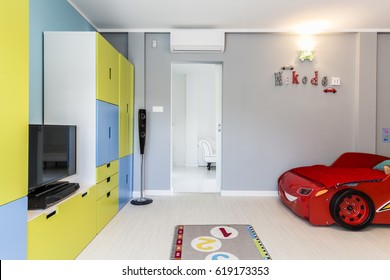 Designer And Colourful Little Boy's Room With A Car Shaped Bed