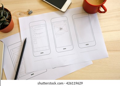 Designer desk with UI wireframe sketches. View from above - Shutterstock ID 426119629